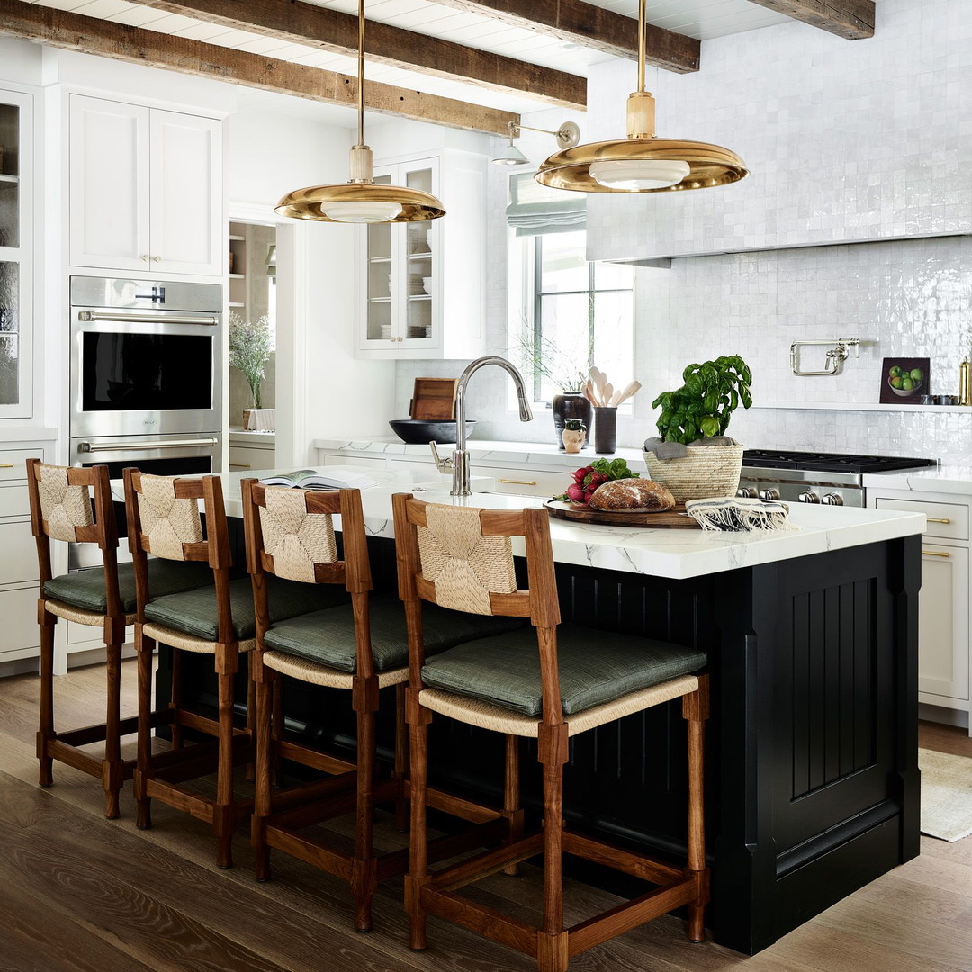 a large kitchen with a center island and wooden chairs