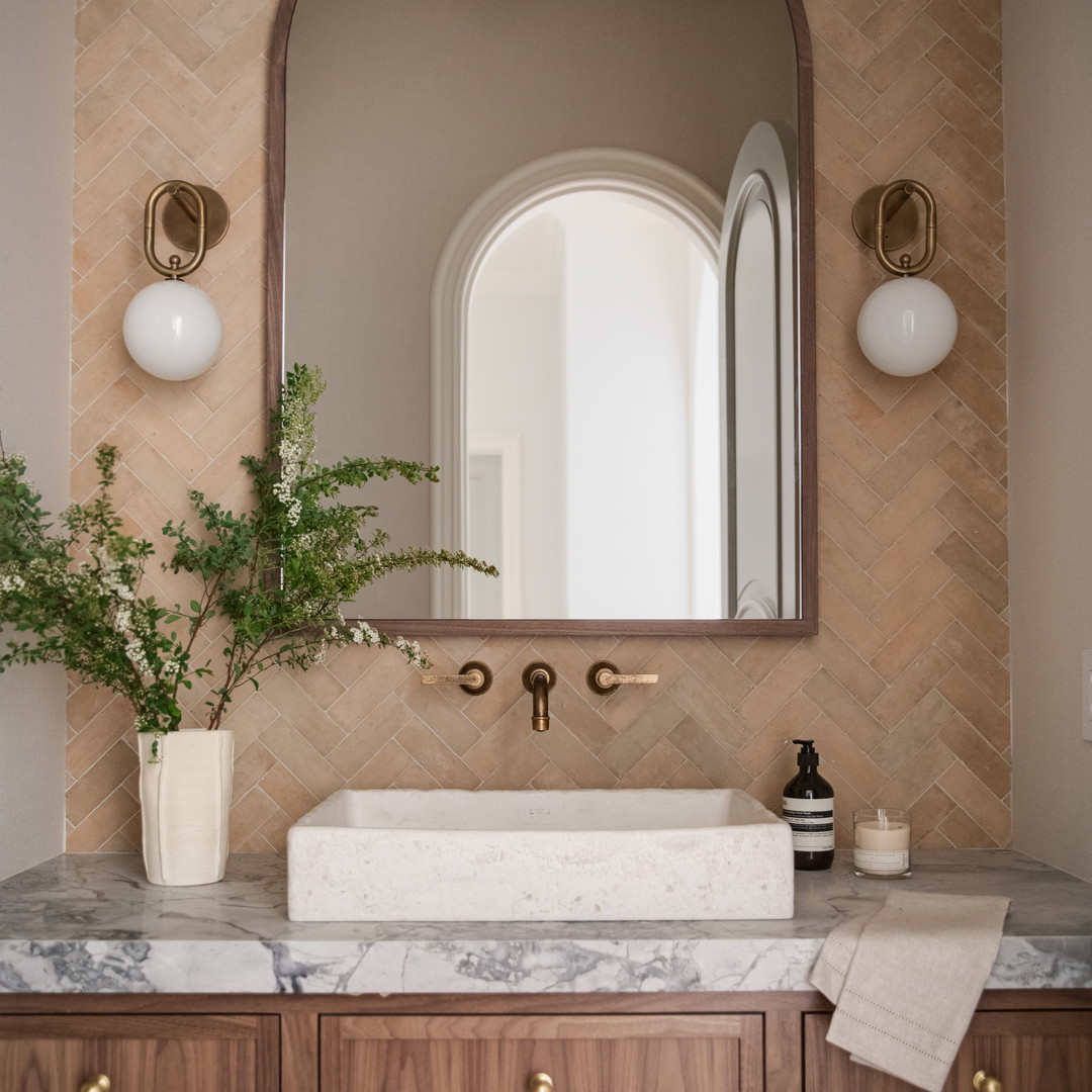 a bathroom with a marble counter top and wooden cabinets