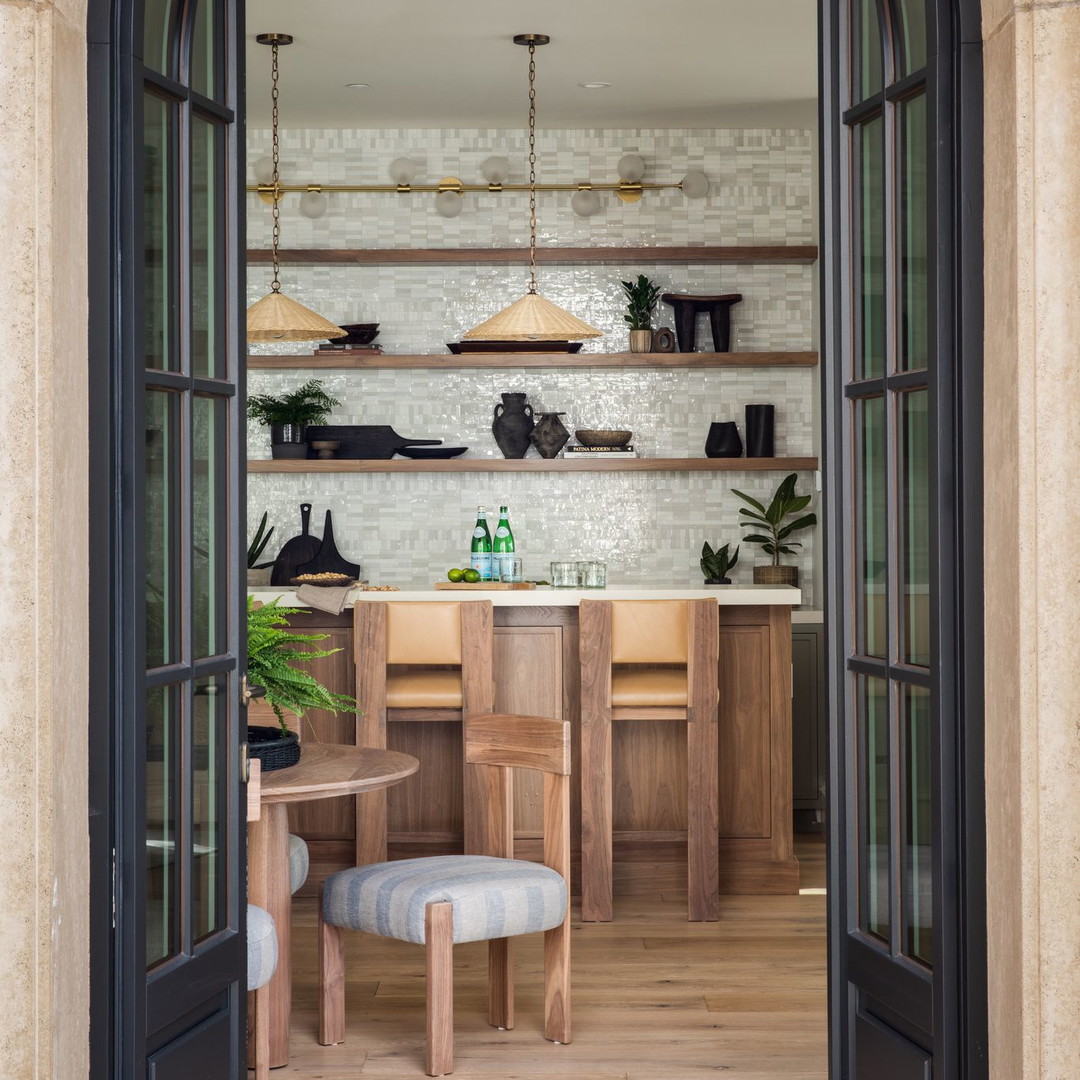 an open doorway leading to a kitchen with a table and chairs