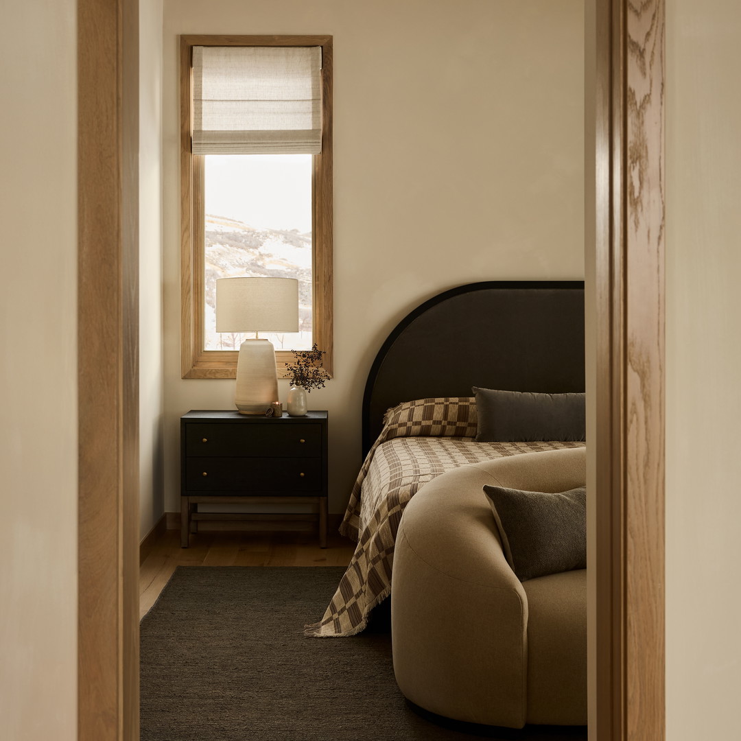 a bed sitting in a bedroom next to a window