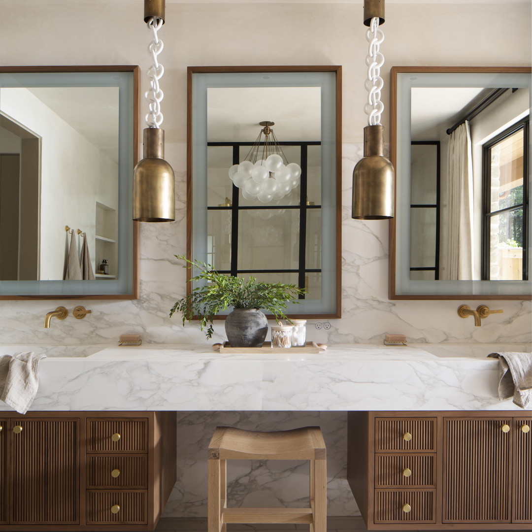 a bathroom with a marble counter top and two mirrors