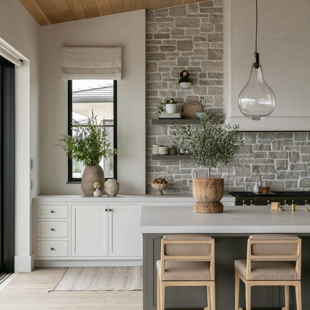 a kitchen with a table and chairs and a brick wall