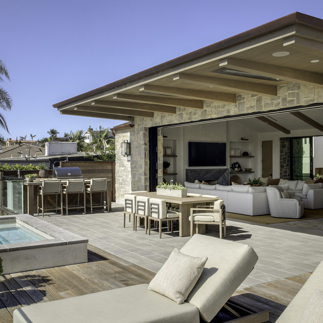 a patio with a table and chairs and a pool