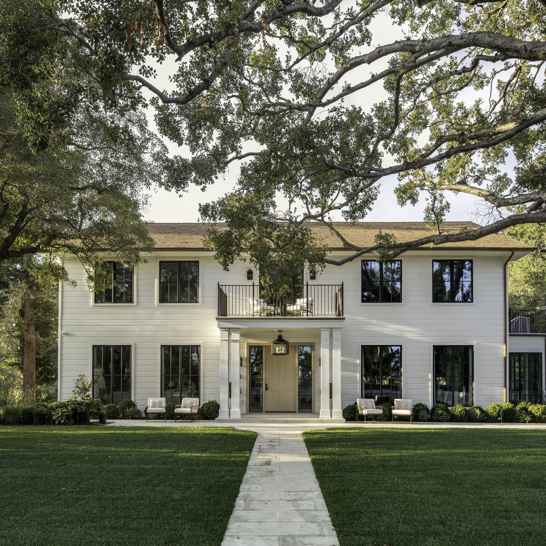 a large white house with a tree in front of it