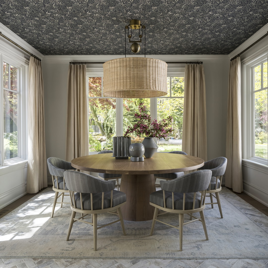 a dining room table surrounded by chairs and a chandelier