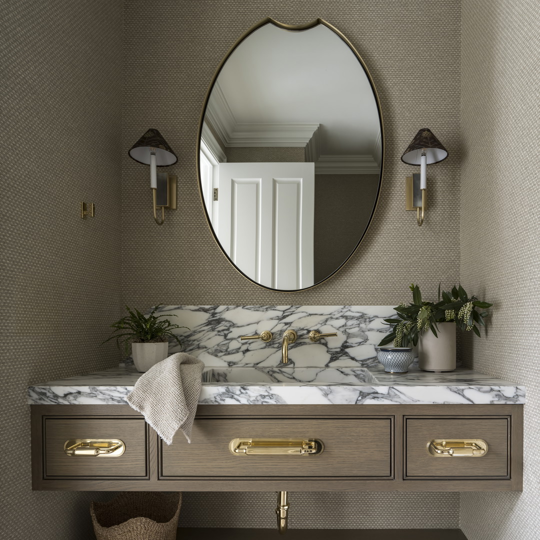 a bathroom with a marble counter top and a round mirror