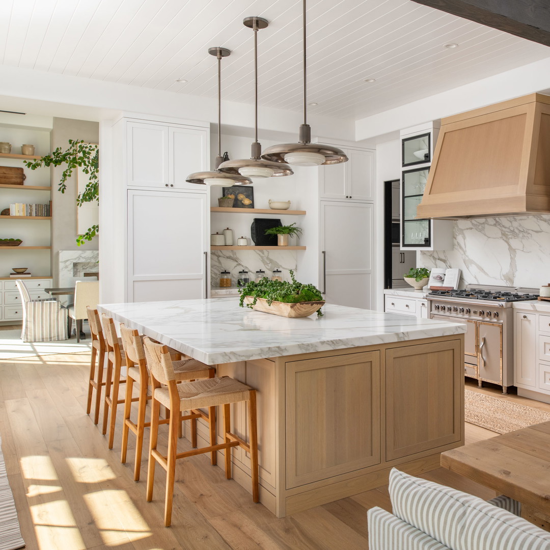 a large kitchen with a center island and wooden floors