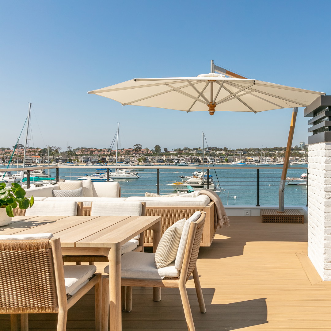 a deck with a table and chairs and an umbrella