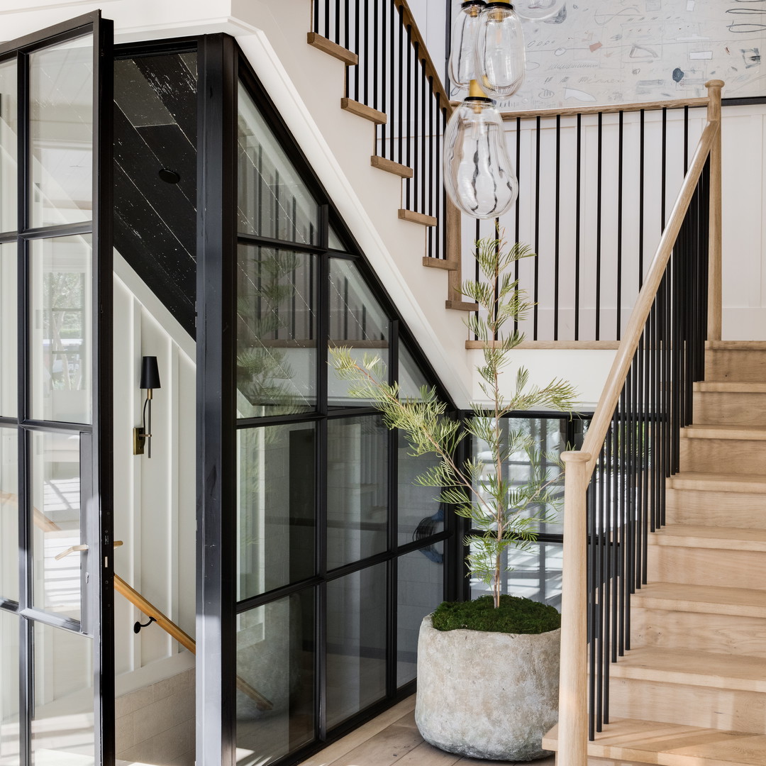 a room with a staircase and a potted plant