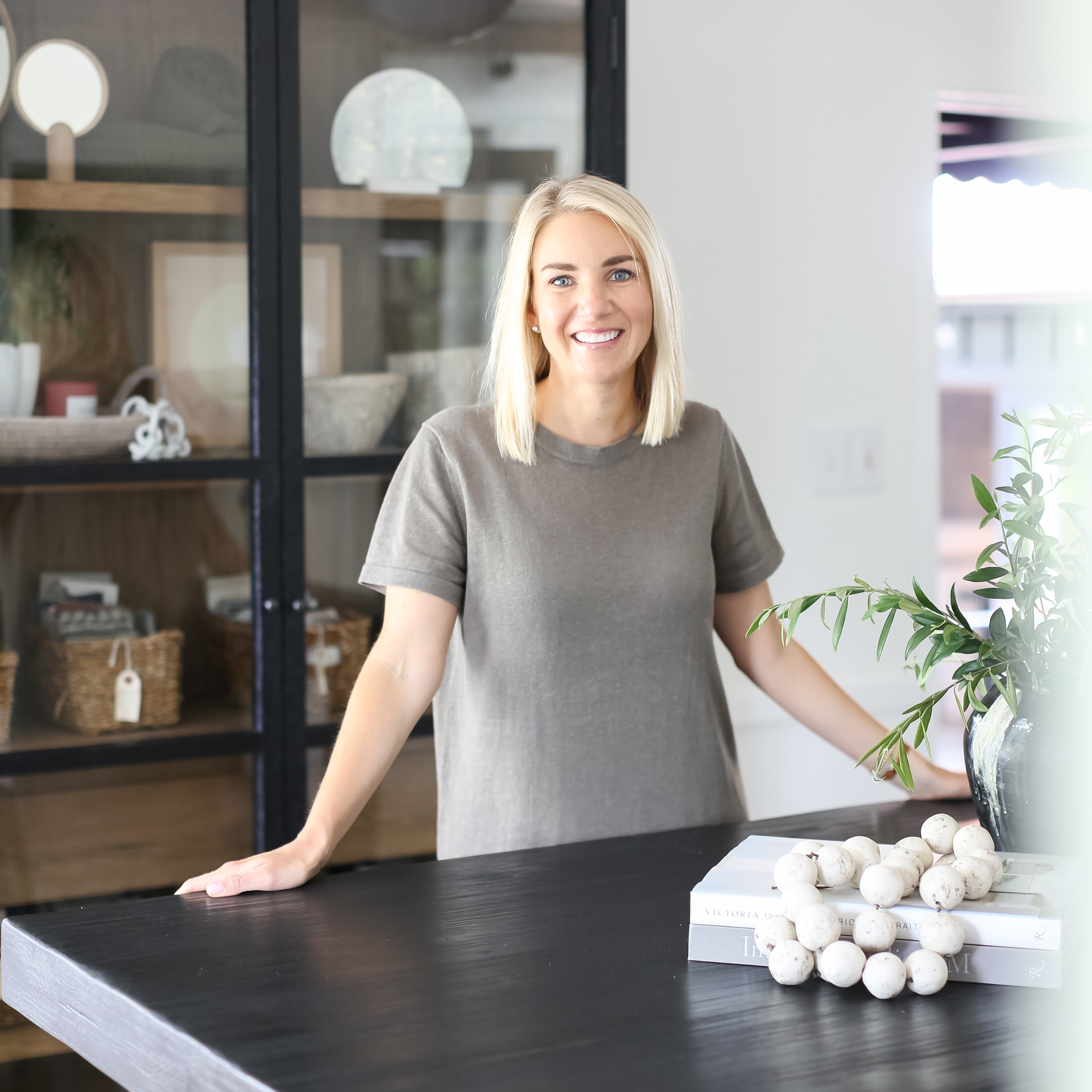 a woman standing in front of a black table