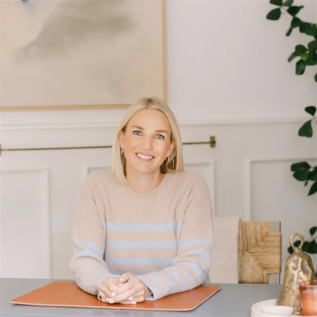 a woman sitting at a table with a book in front of her