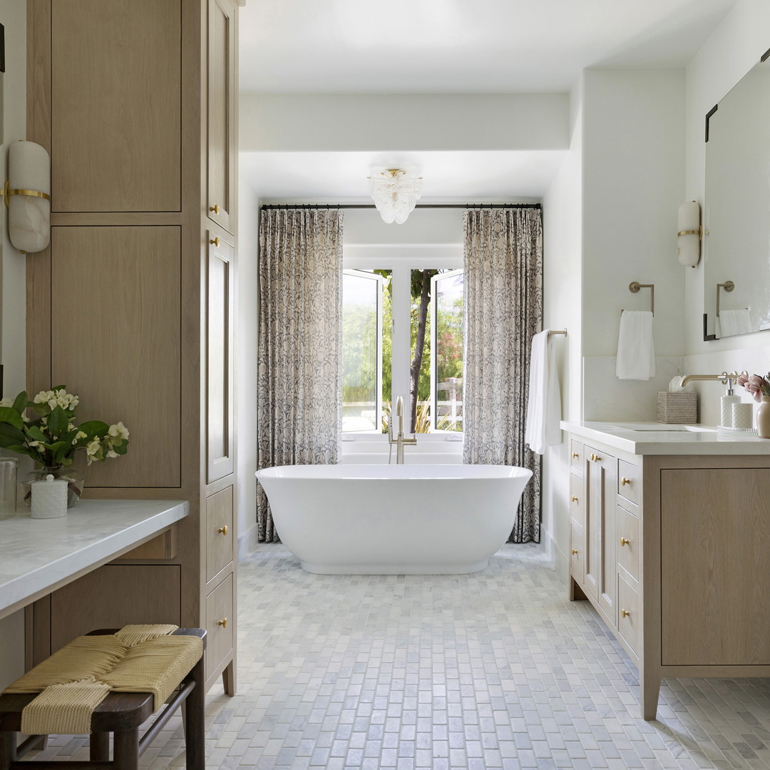 a bathroom with a tub, sink, and mirror