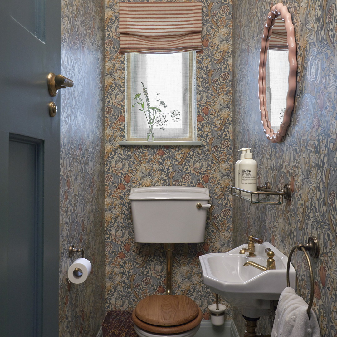 a bathroom with a toilet, sink and mirror