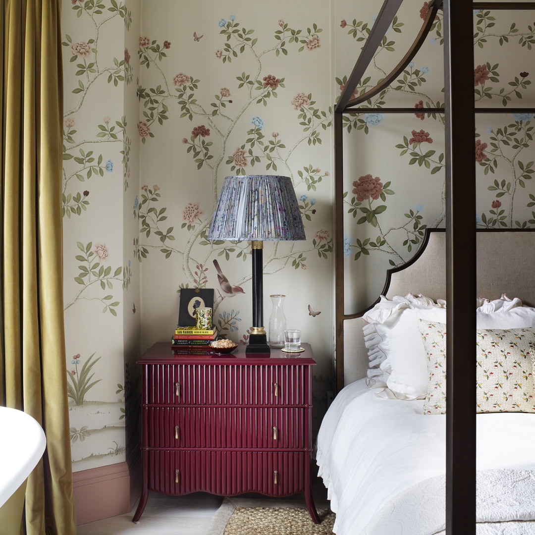 a bedroom with floral wallpaper and a canopy bed