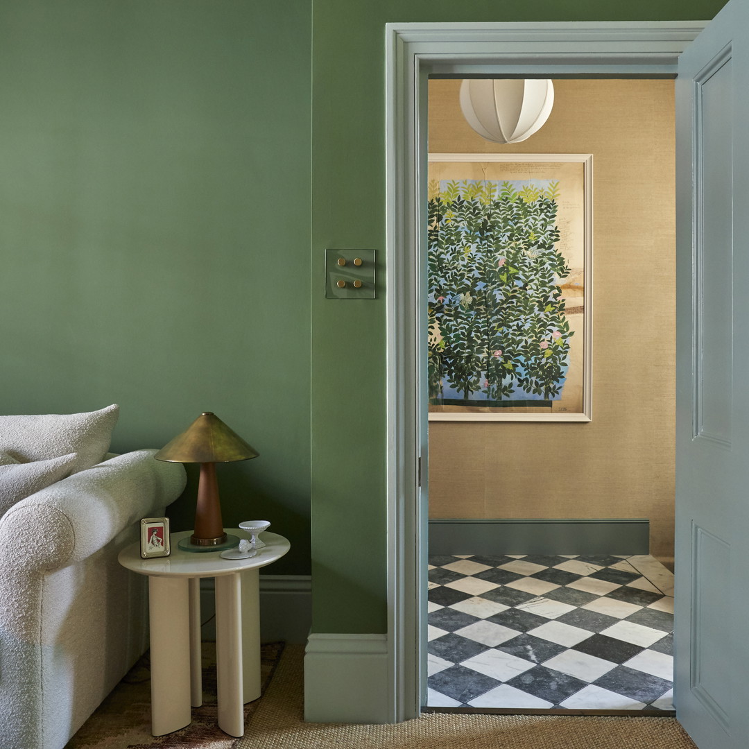 a living room with green walls and a checkered floor