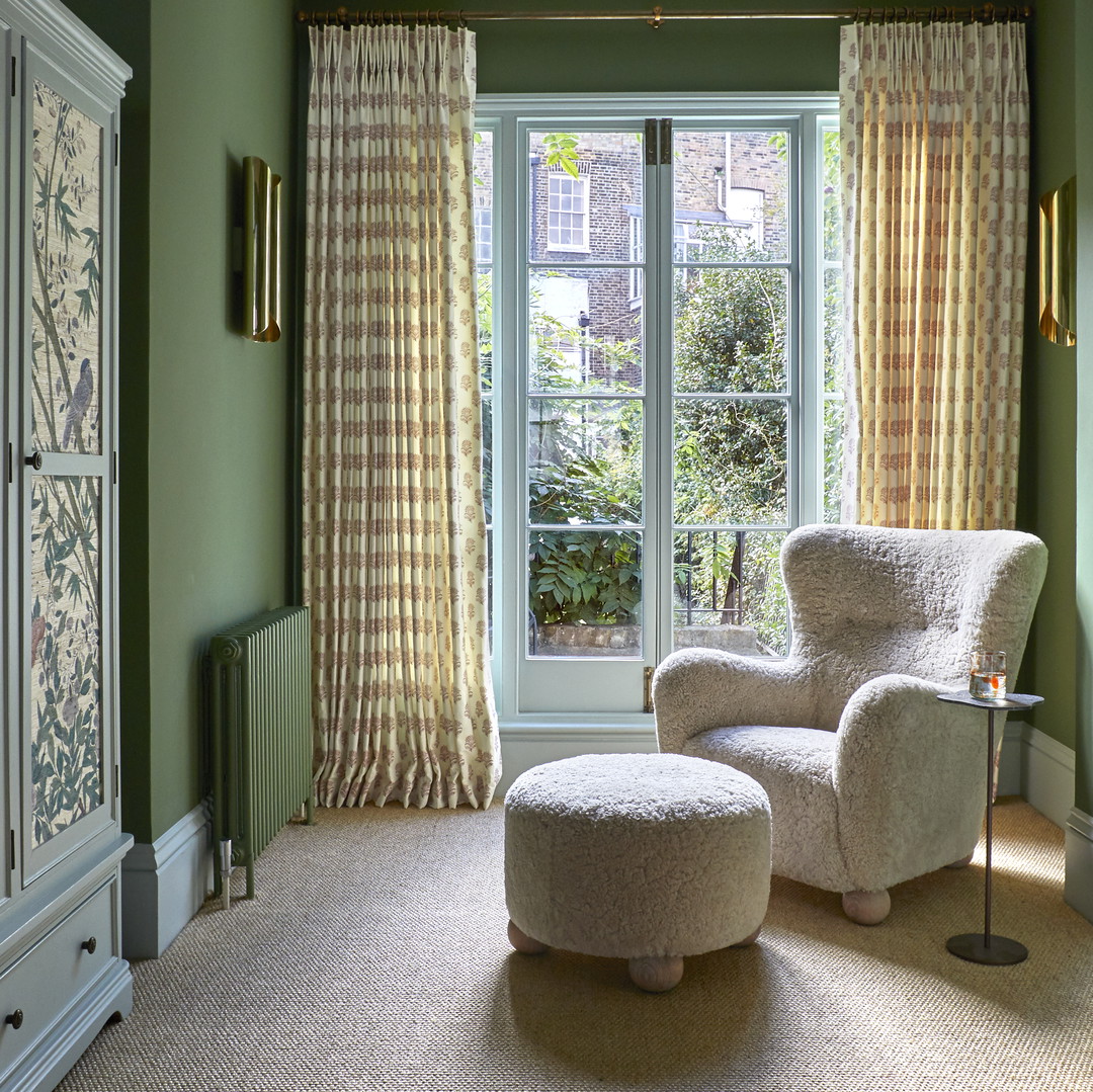 a living room with green walls and a white chair