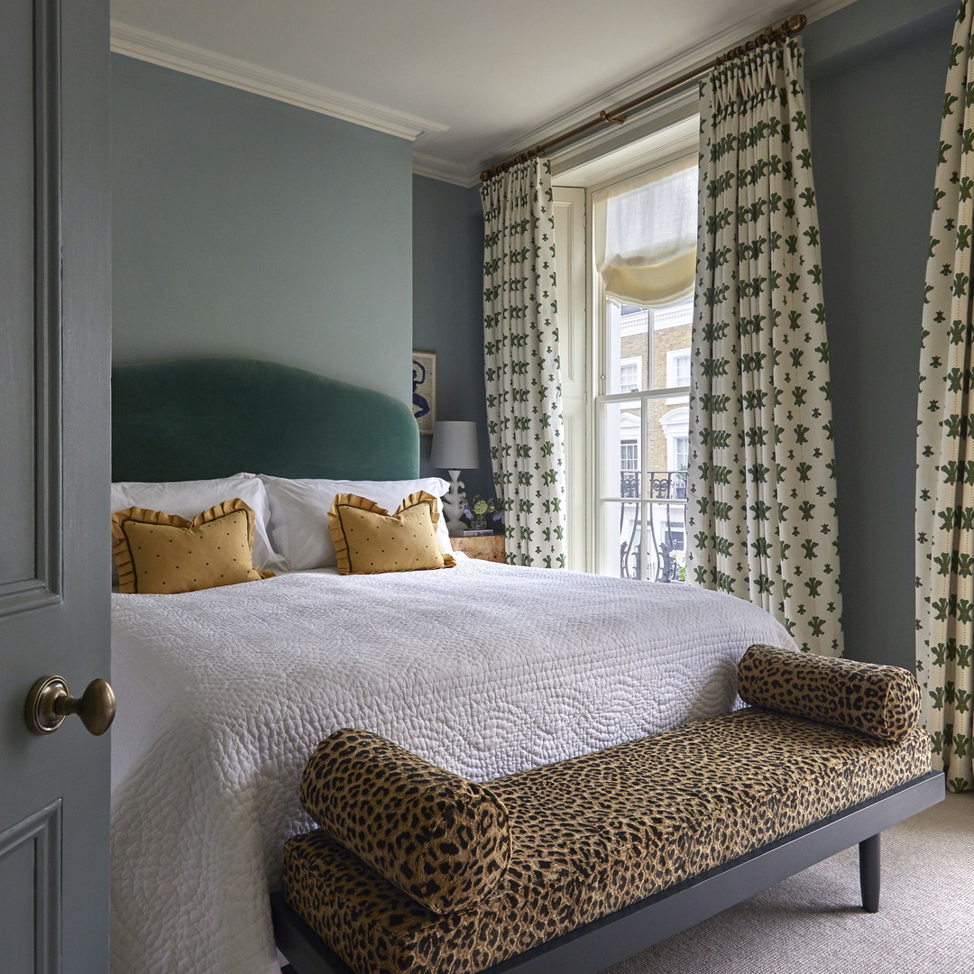 a bedroom with a leopard print bench in front of the bed