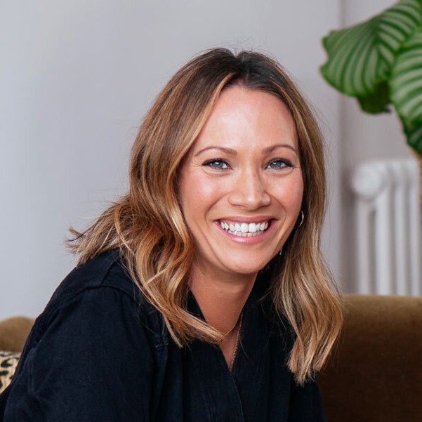 a woman sitting on a couch smiling for the camera