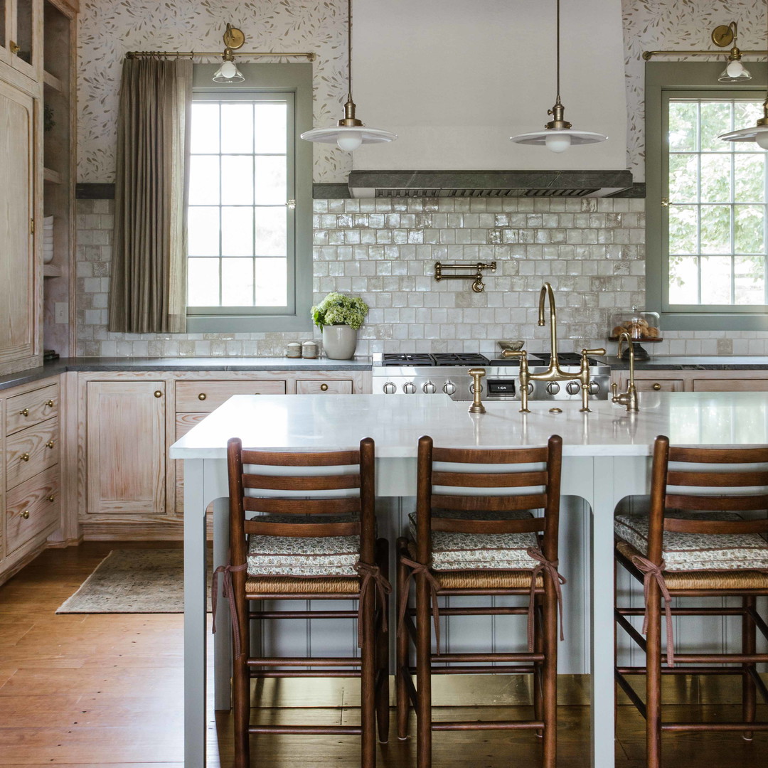 a large kitchen with a center island and wooden chairs