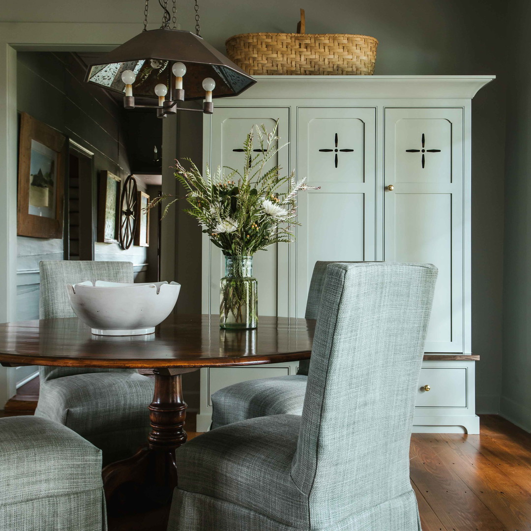 a dining room table with chairs and a bowl of flowers