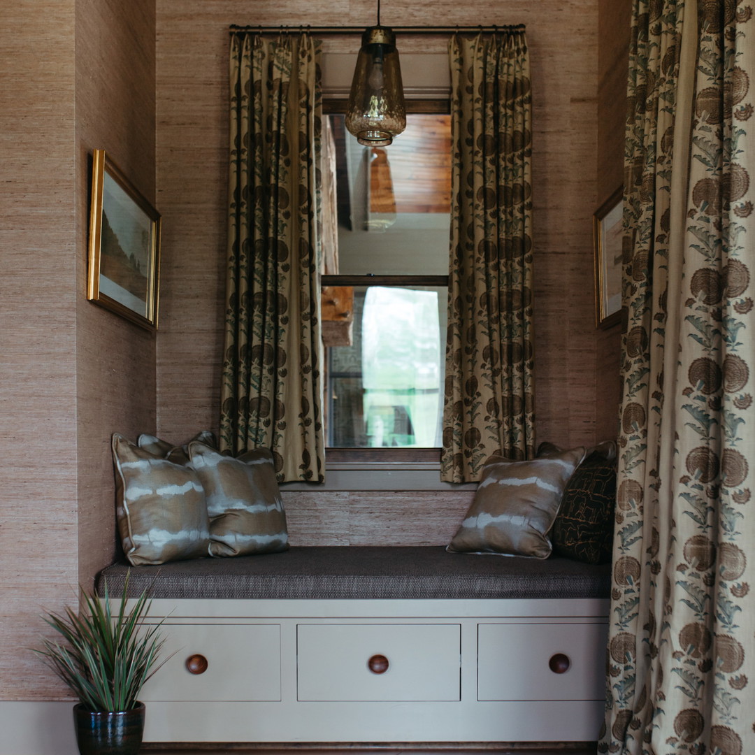 a window seat in a room with curtains and a potted plant