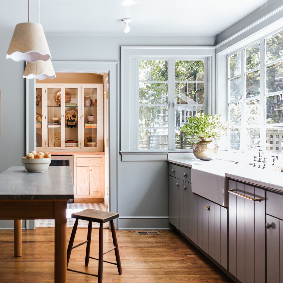 a kitchen with a wooden table and two stools