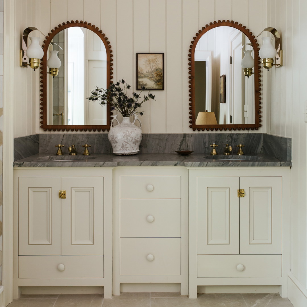 a bathroom with two sinks and two mirrors