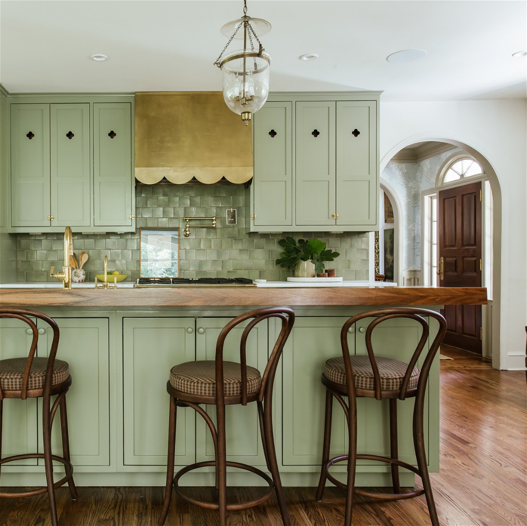a kitchen with green cabinets and wooden floors