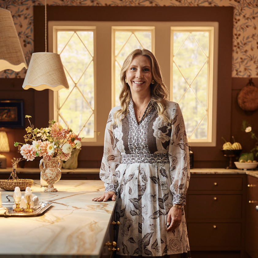 a woman standing in a kitchen next to a table