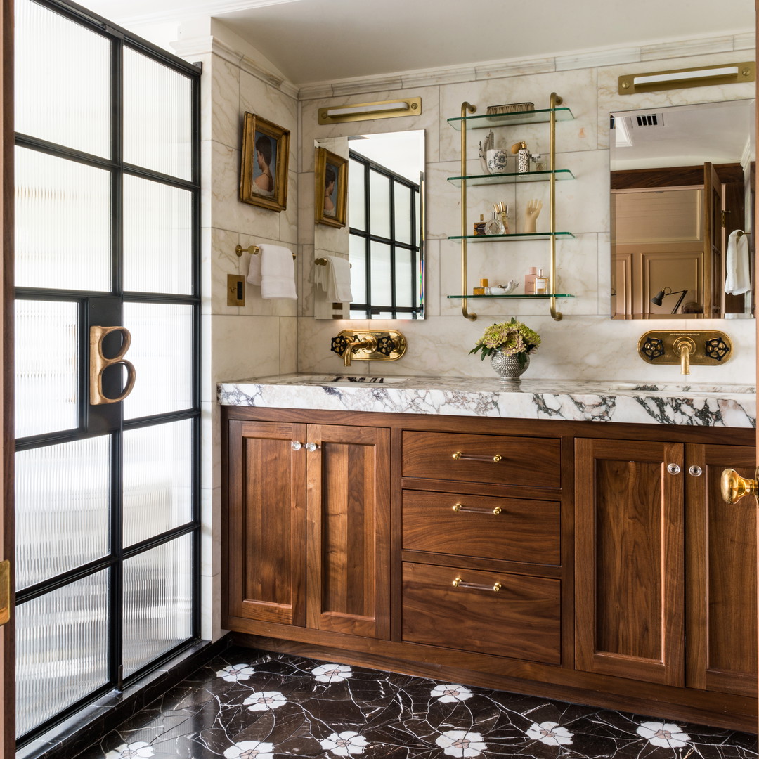 a bathroom with a marble counter top and wooden cabinets