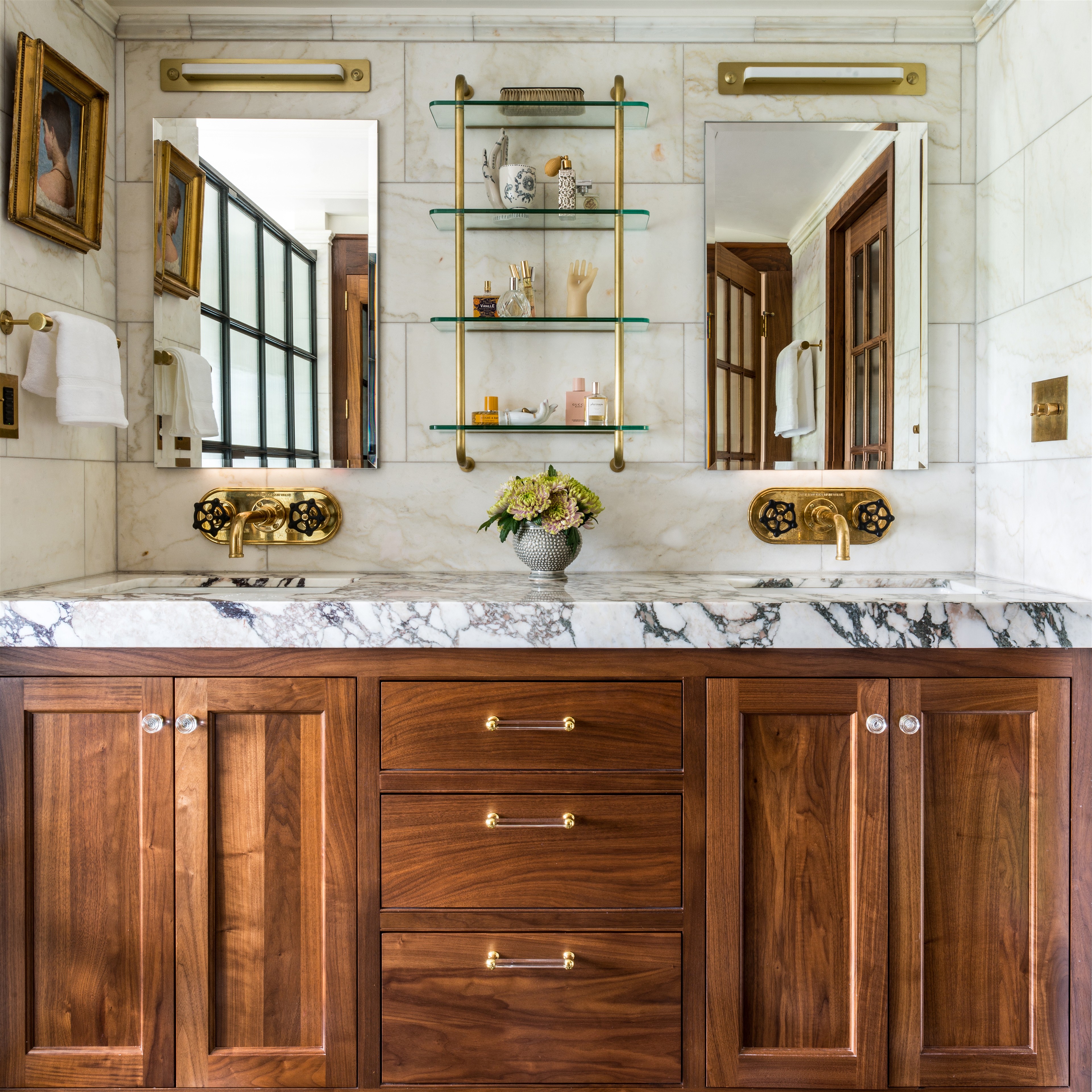 a bathroom with marble counter tops and wooden cabinets