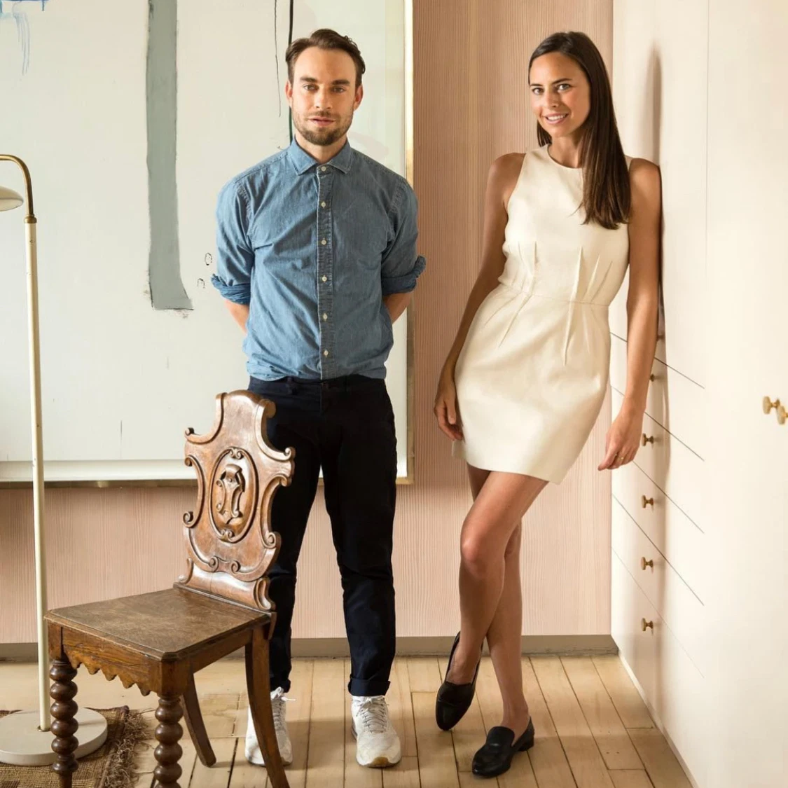 a man and a woman standing next to a chair