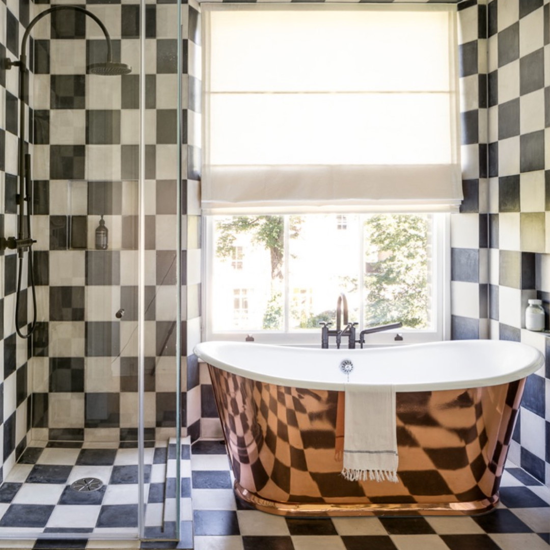 a bath tub sitting next to a window in a bathroom