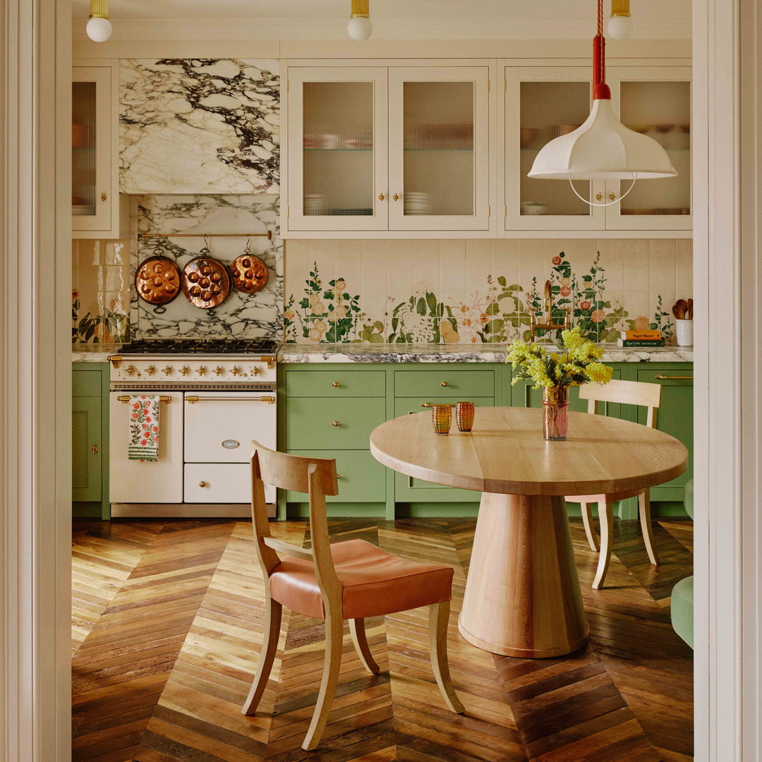 a kitchen with green cabinets and a wooden table