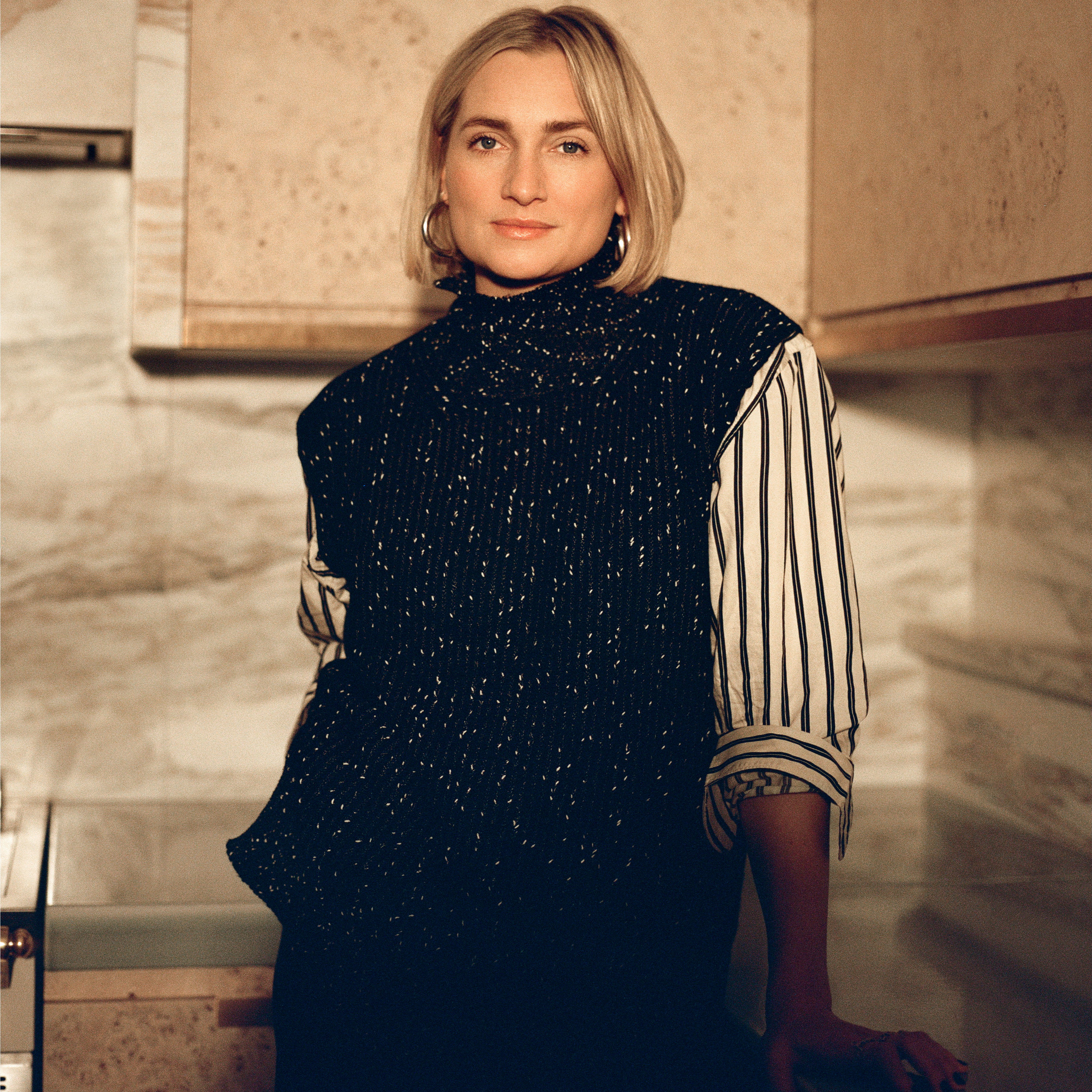 a woman standing in a kitchen next to a counter