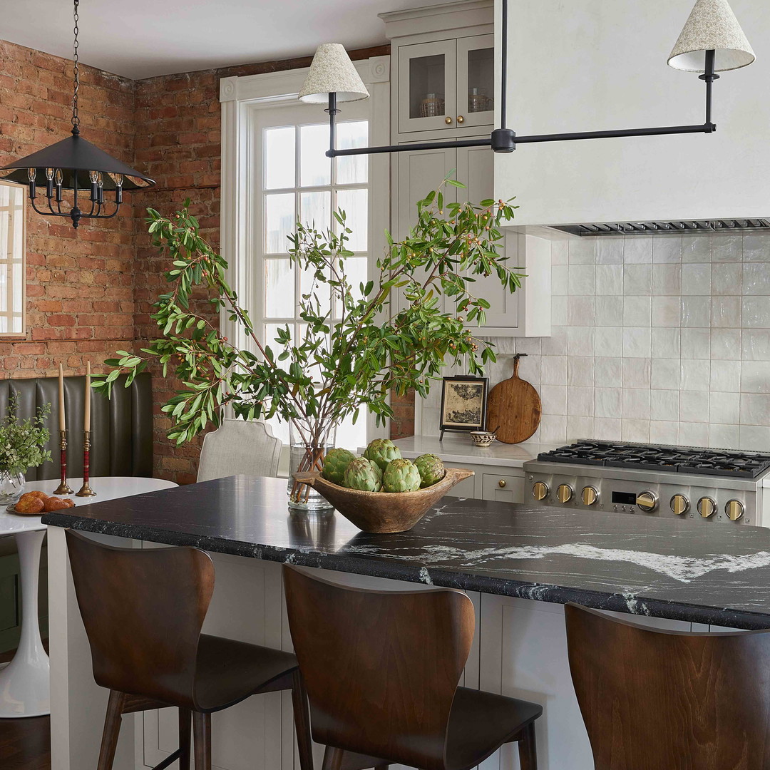 a kitchen with a center island with a bowl of fruit on it