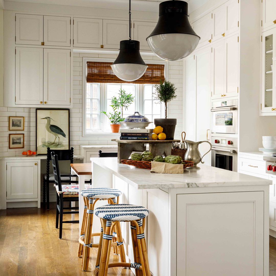 a kitchen with white cabinets and wooden floors