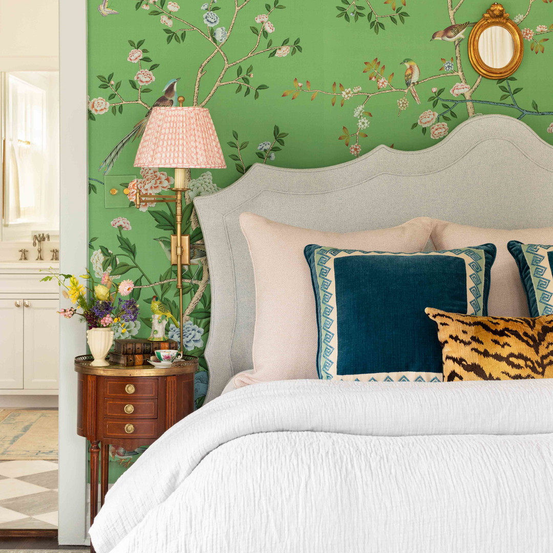 a bedroom with a green wall and a white bed