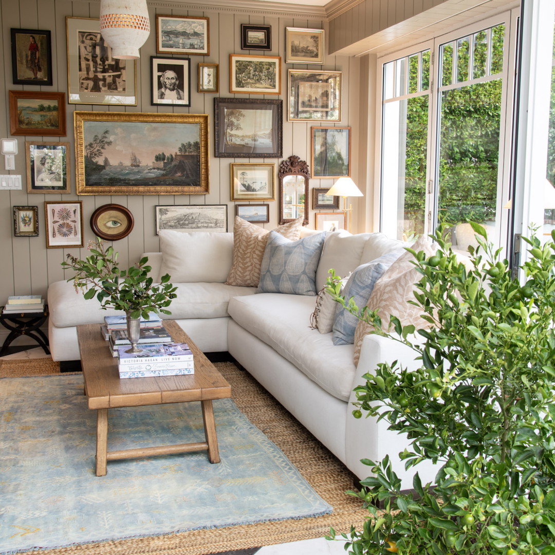 a living room filled with furniture and pictures on the wall