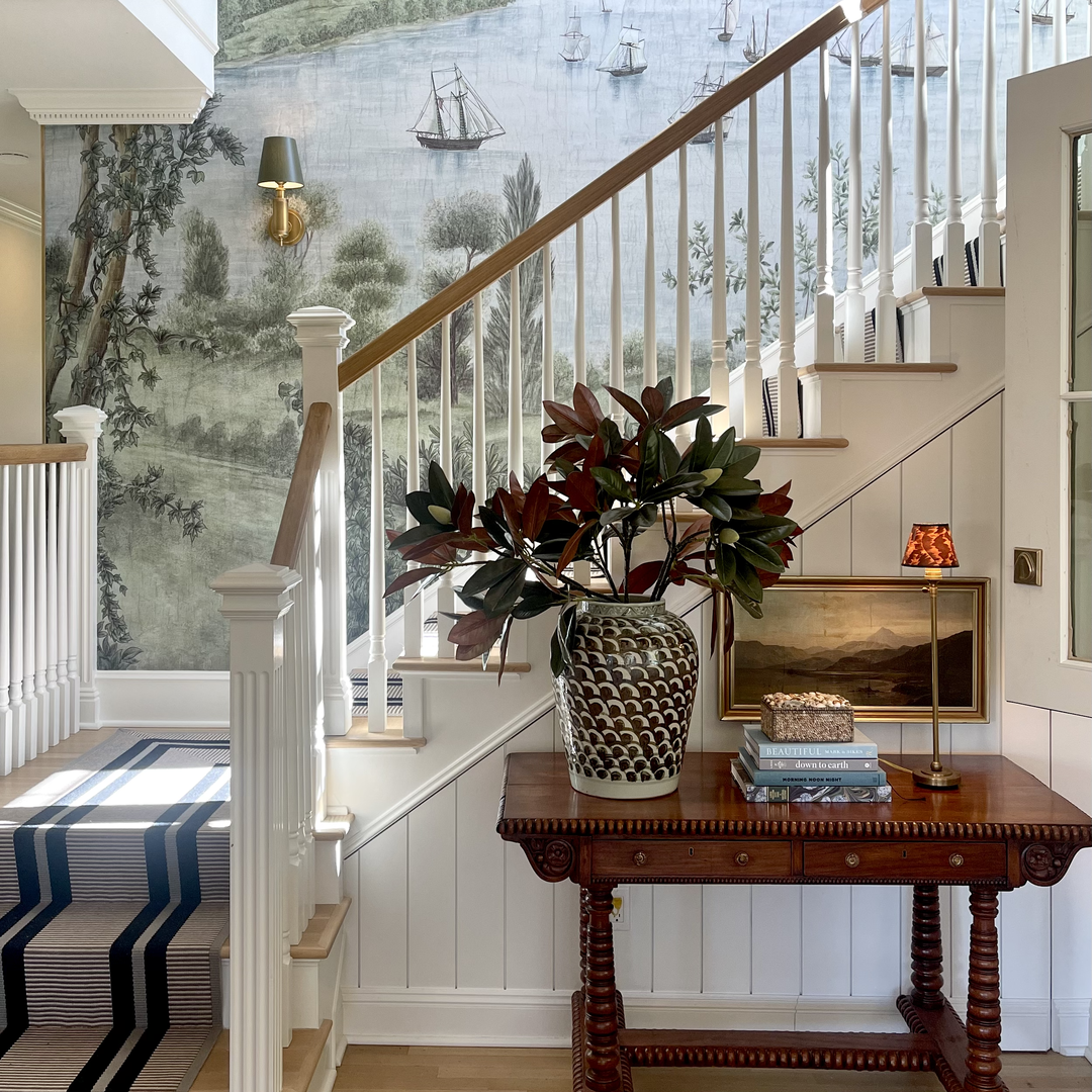 a vase of flowers sitting on a table in front of a staircase