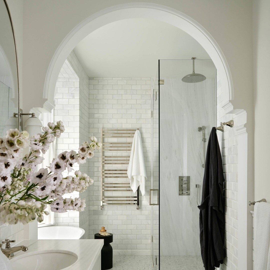 a white bathroom with a glass shower door