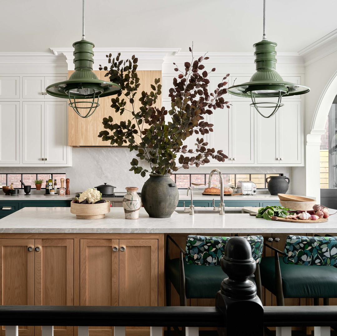 a large kitchen with a center island and green chairs