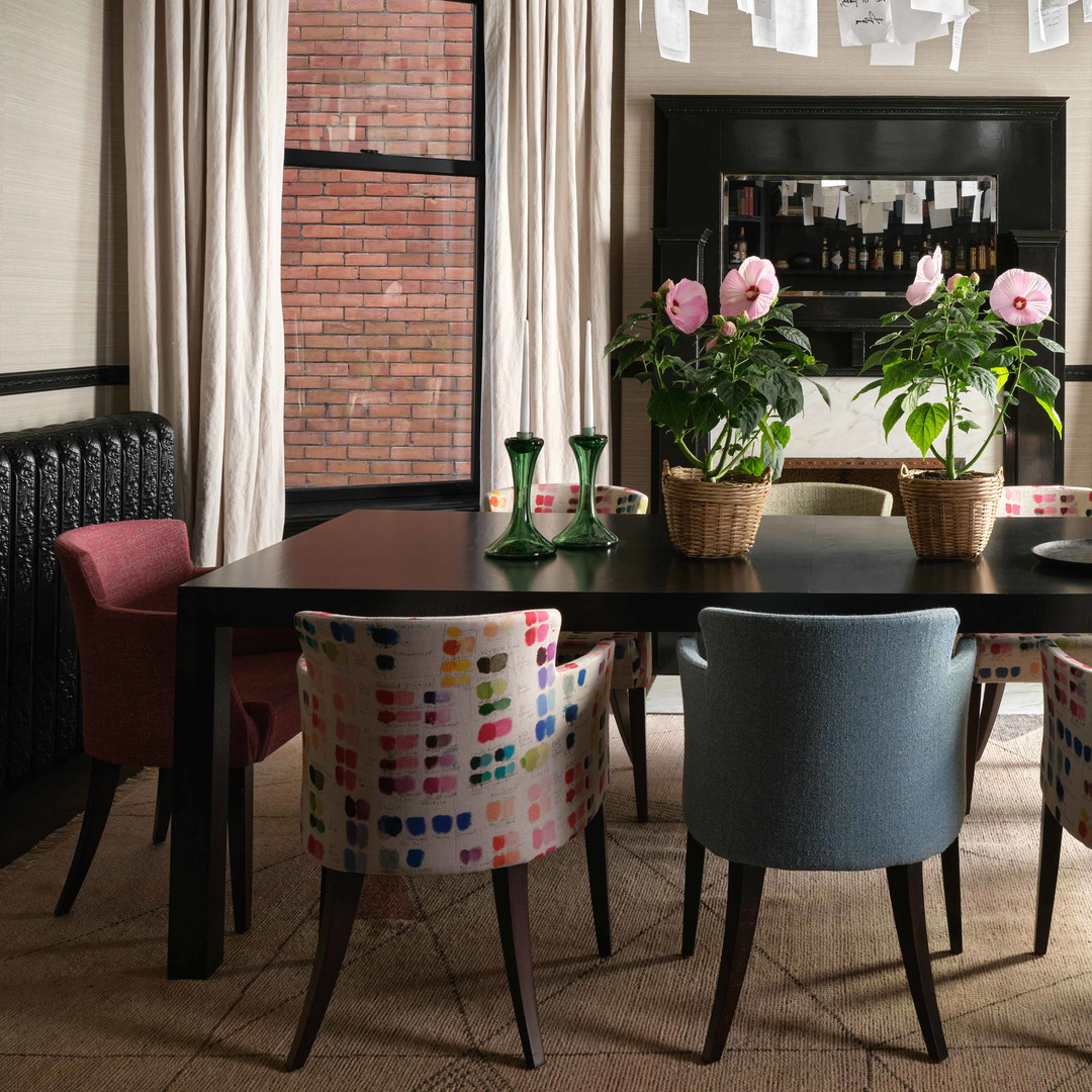 a dining room with a table, chairs, and potted plants