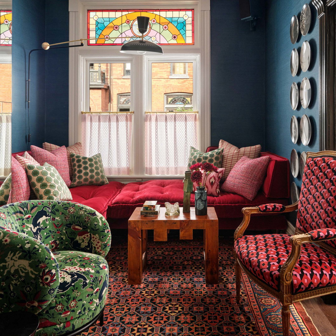 a living room filled with furniture and a stained glass window