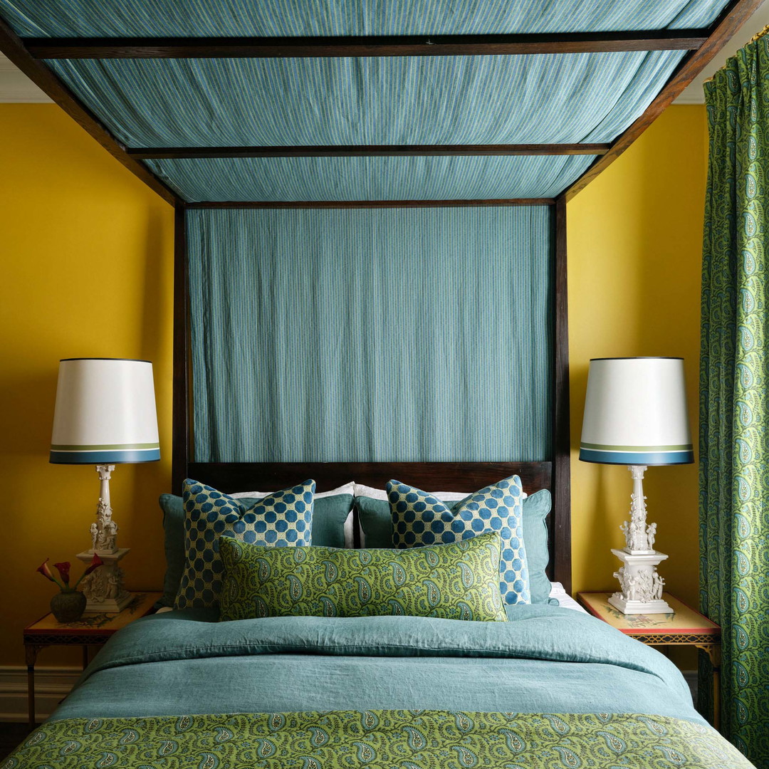 a bedroom with a canopy bed and two lamps