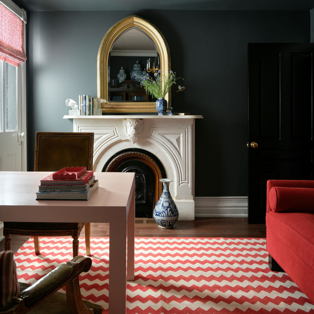 a living room with a red couch and a fireplace