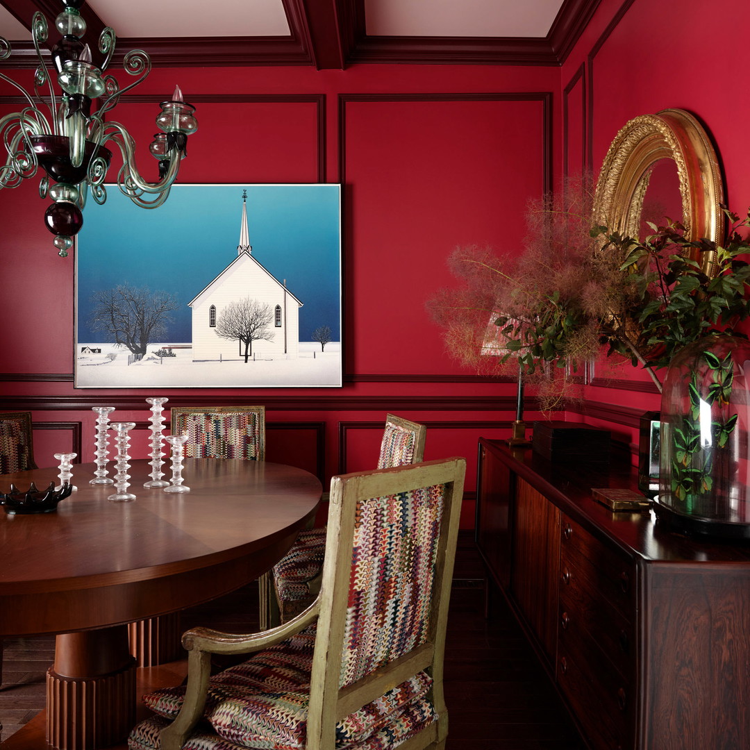 a dining room with red walls and a chandelier