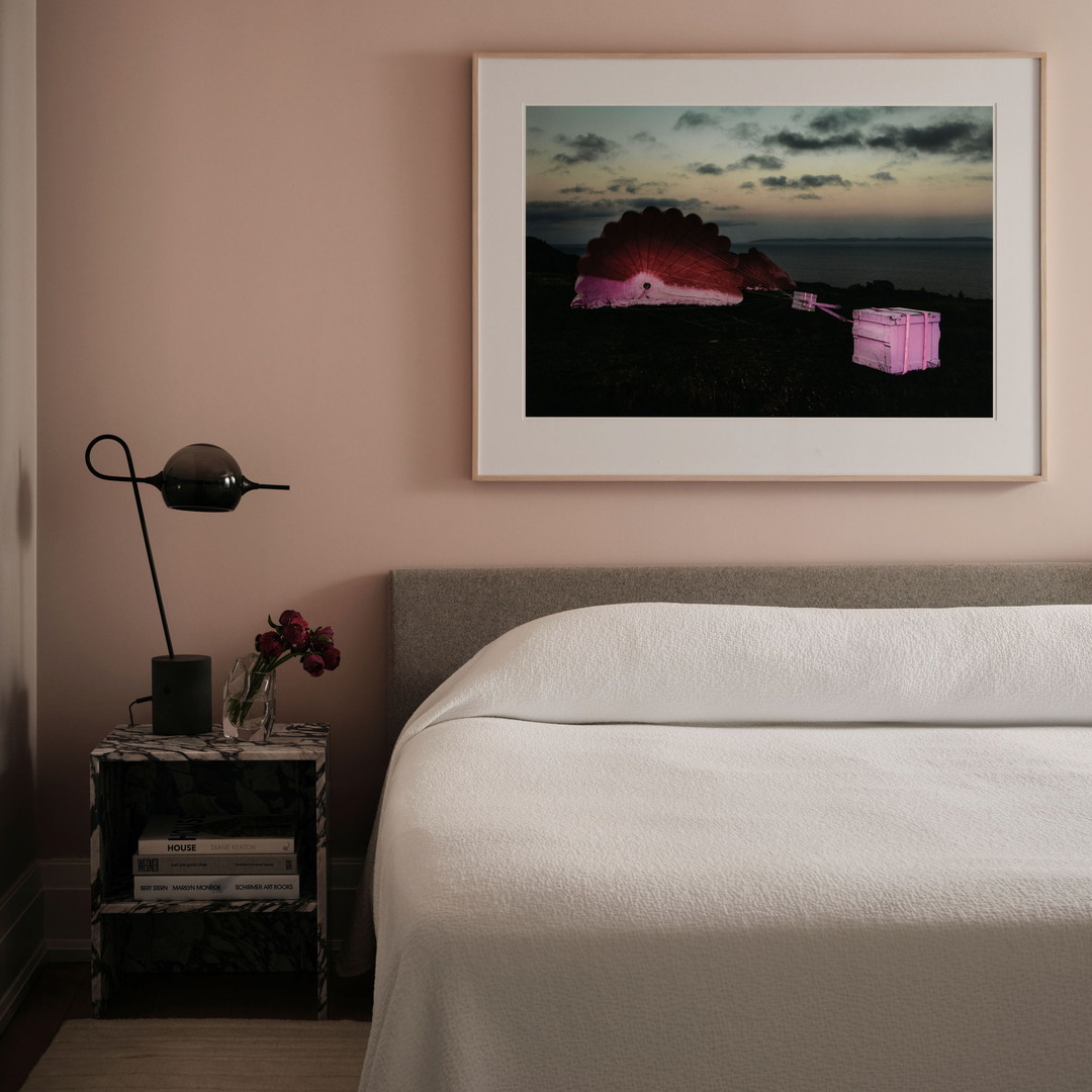 a bedroom with a bed and a picture on the wall