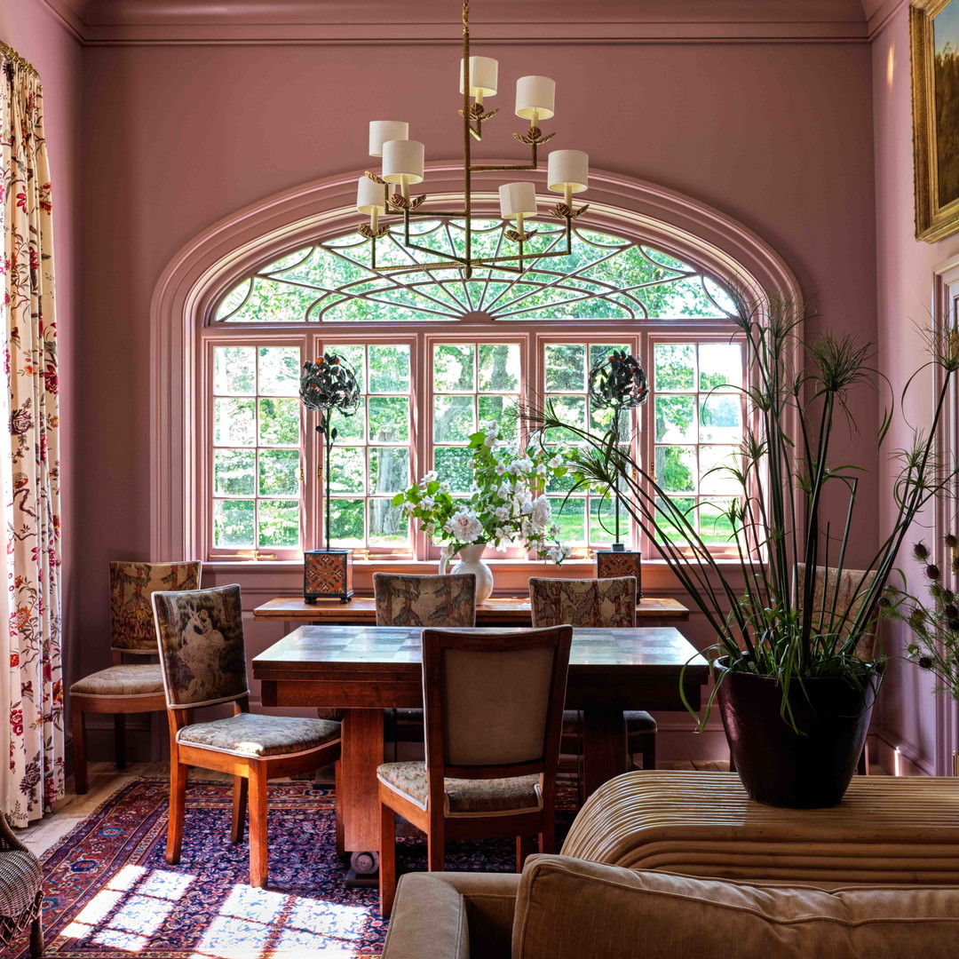 a dining room with a table and chairs and a potted plant