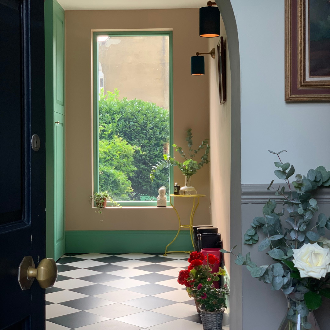 a room with a checkered floor and a green door